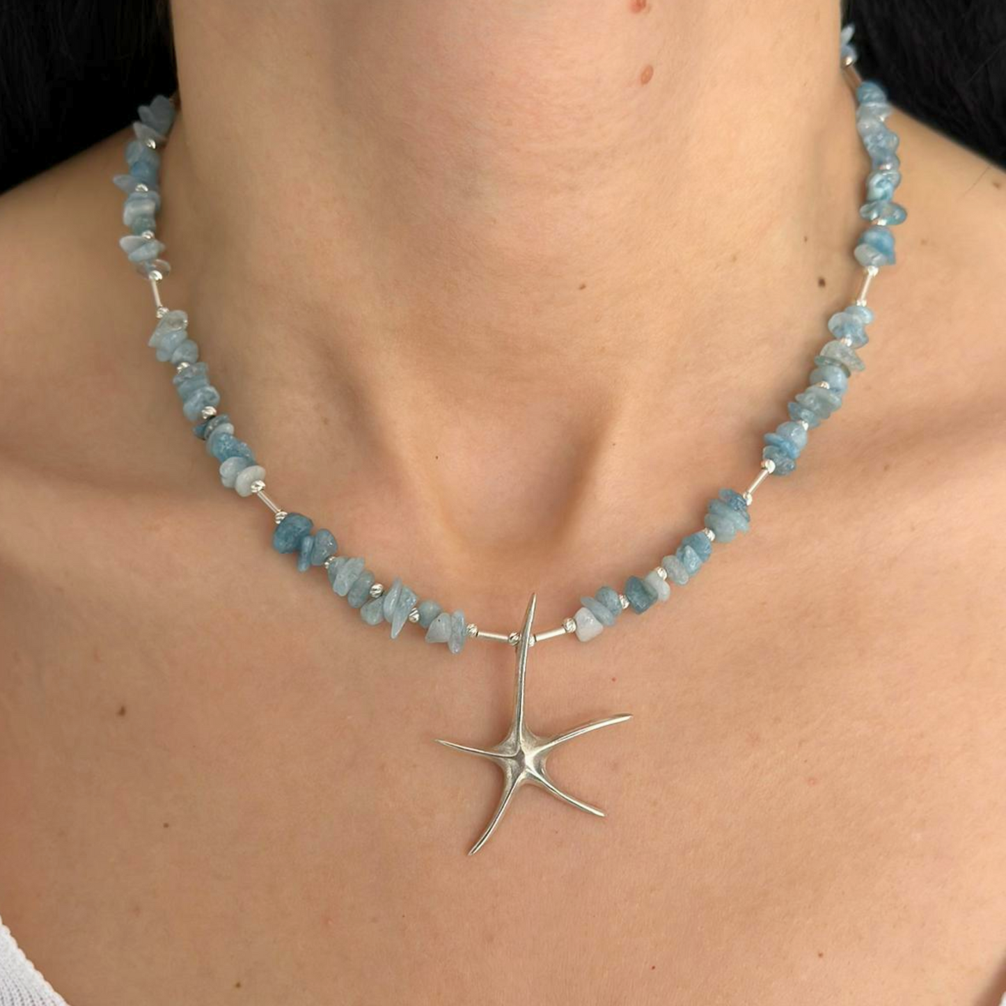 Aquamarine starfish necklace with handmade 925 silver pendant and gemstone beads worn around a neck for a chic accessory look.