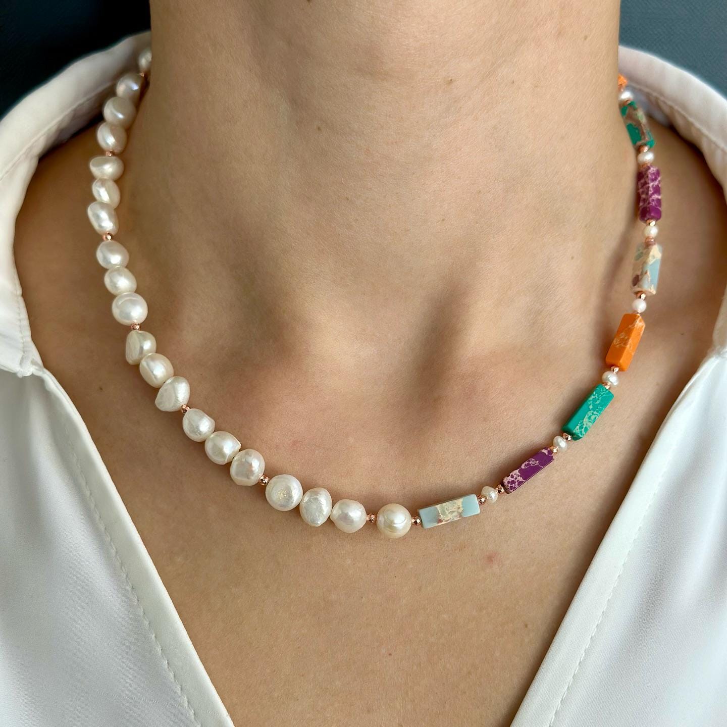Liza necklace featuring variscite, hematite, and pearl beads with rose gold plated silver detail on a model's neck.