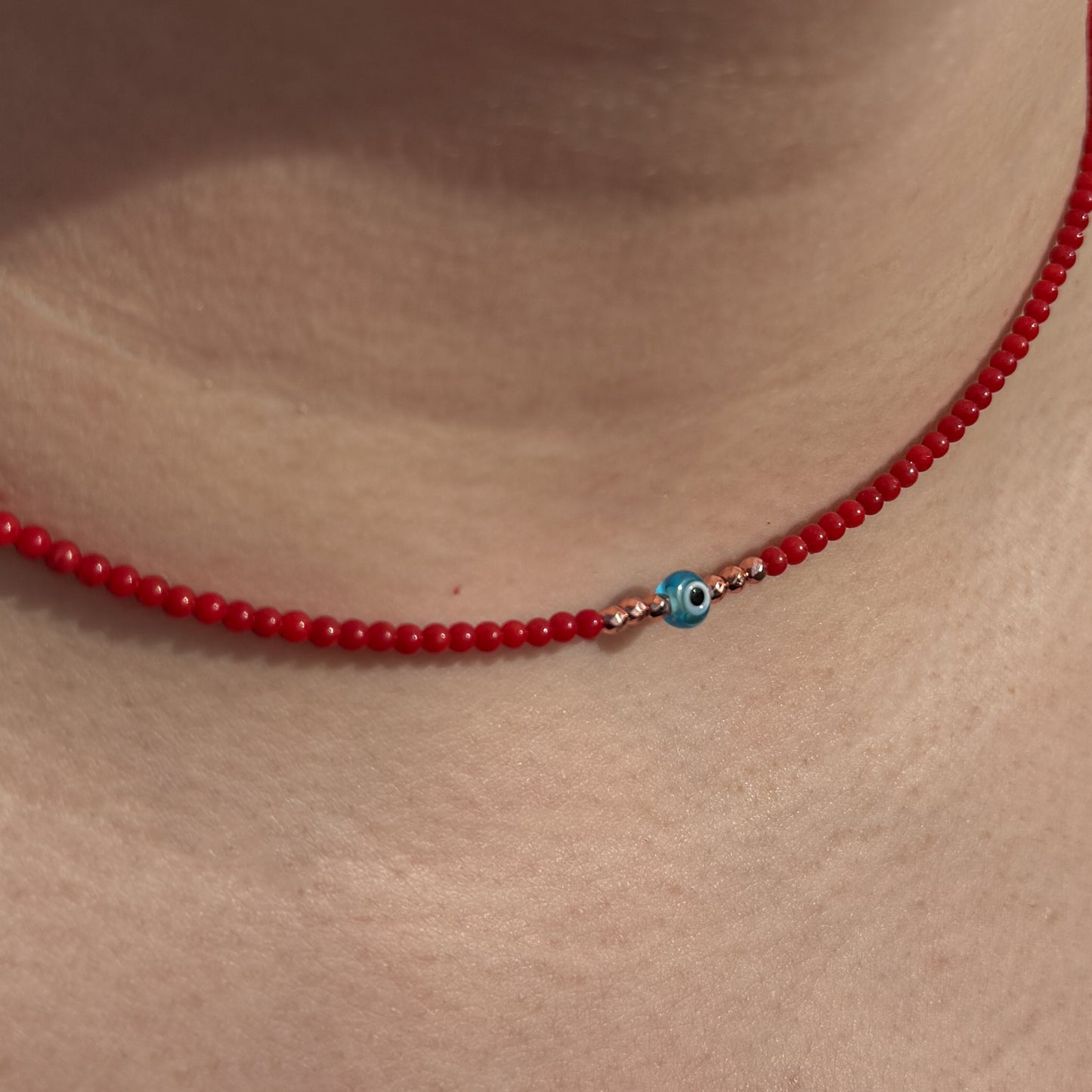 Elegant Mini Evil Eye Necklace with Coral Gemstone Beads on a choker setting, perfect for bringing a touch of charm and style.