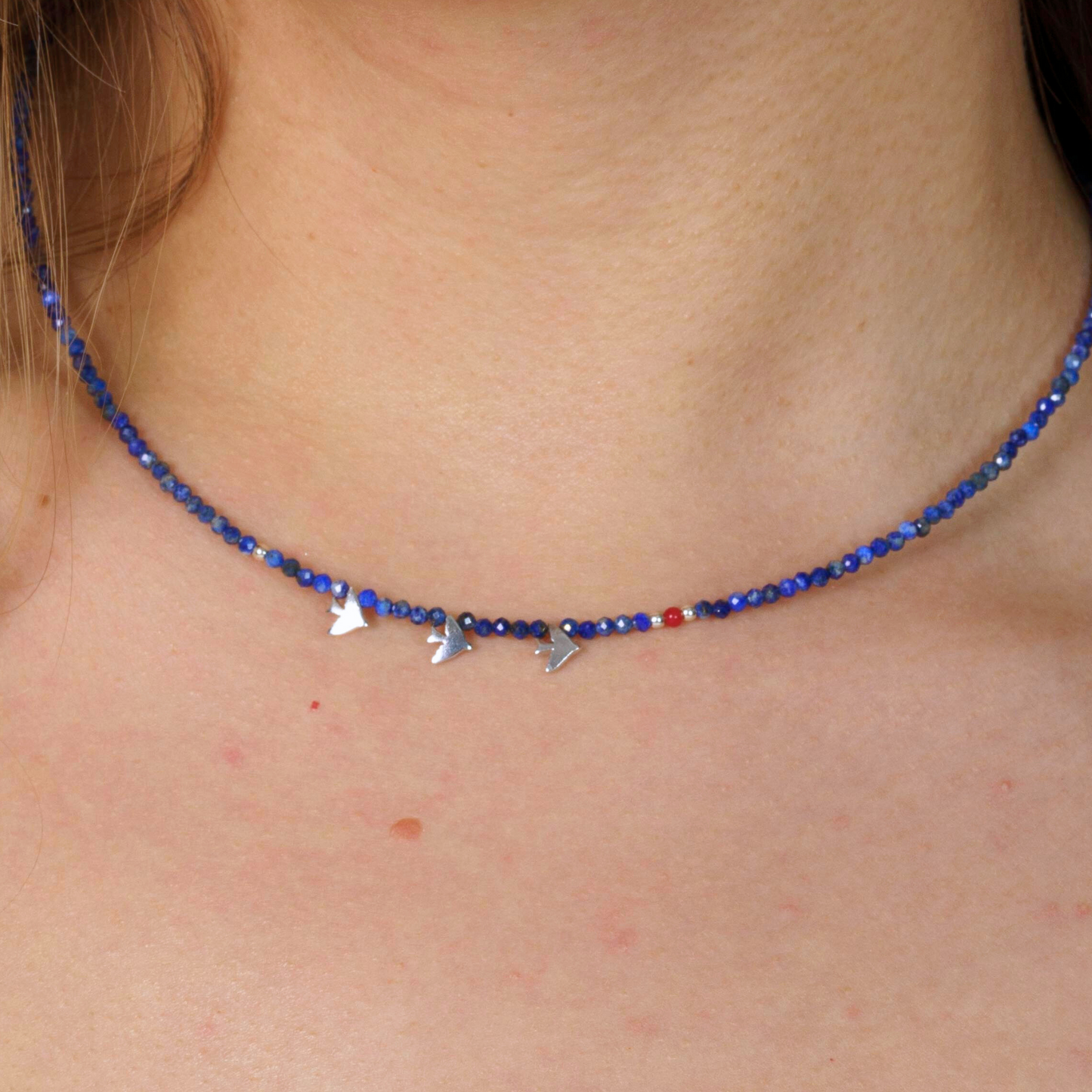 Elegant minimal lapis lazuli beaded necklace adorned with silver three-bird pendants, perfect for chic casual style.