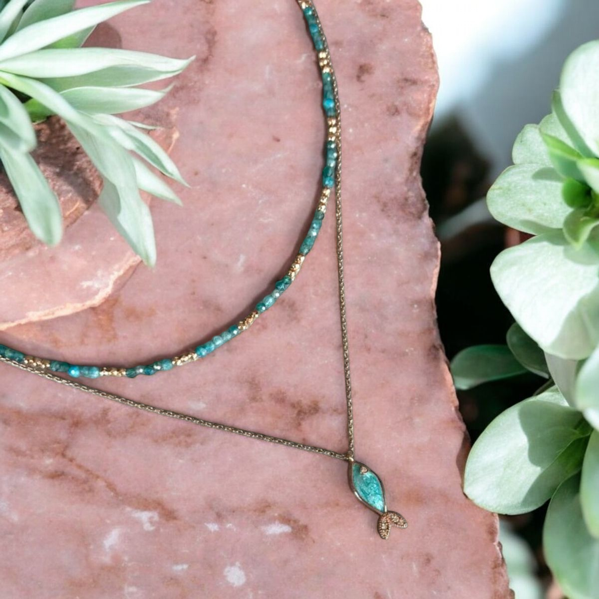 Azure Silver Fish and Apatite Gemstone Necklaces Set on Pink Stone with Greenery