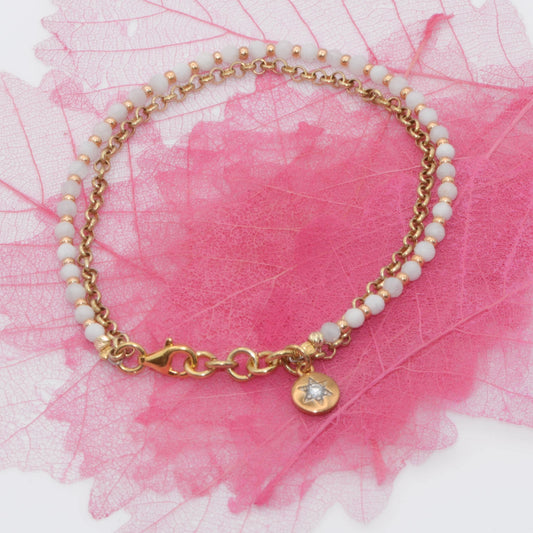 Handcrafted Moonstone and Hematite star bracelet with rose gold finish, displayed on a decorative pink background.
