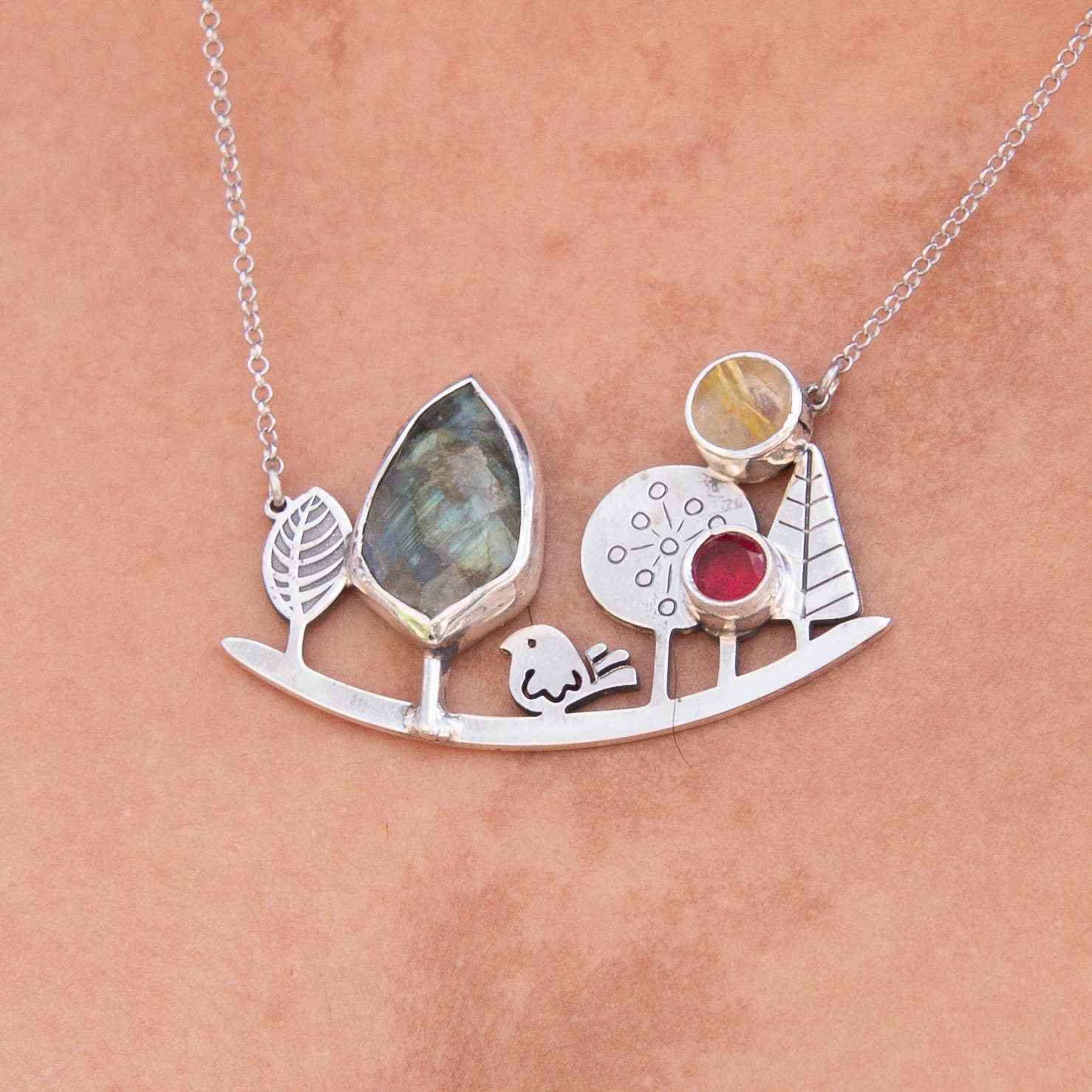 Elegant silver necklace featuring a landscape-inspired design with gemstones and intricate detailing, perfect for any occasion.