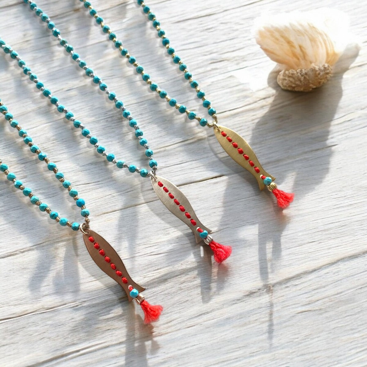 Artisan landscape bird and tree necklace featuring labradorite, rutile quartz, and garnet gemstones on wooden surface.