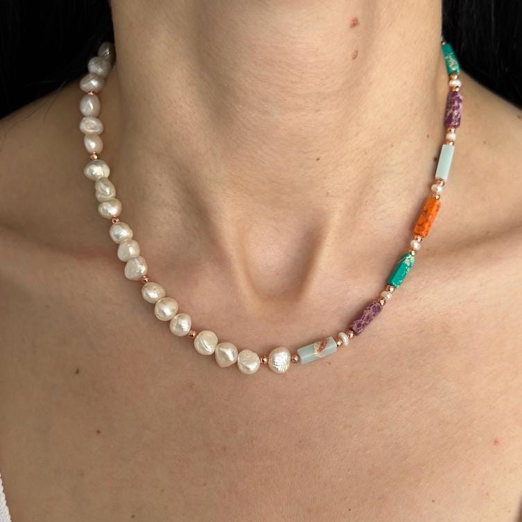 A Liza necklace featuring variscite, hematite, pearl beads, and rose gold plating on silver, worn elegantly.