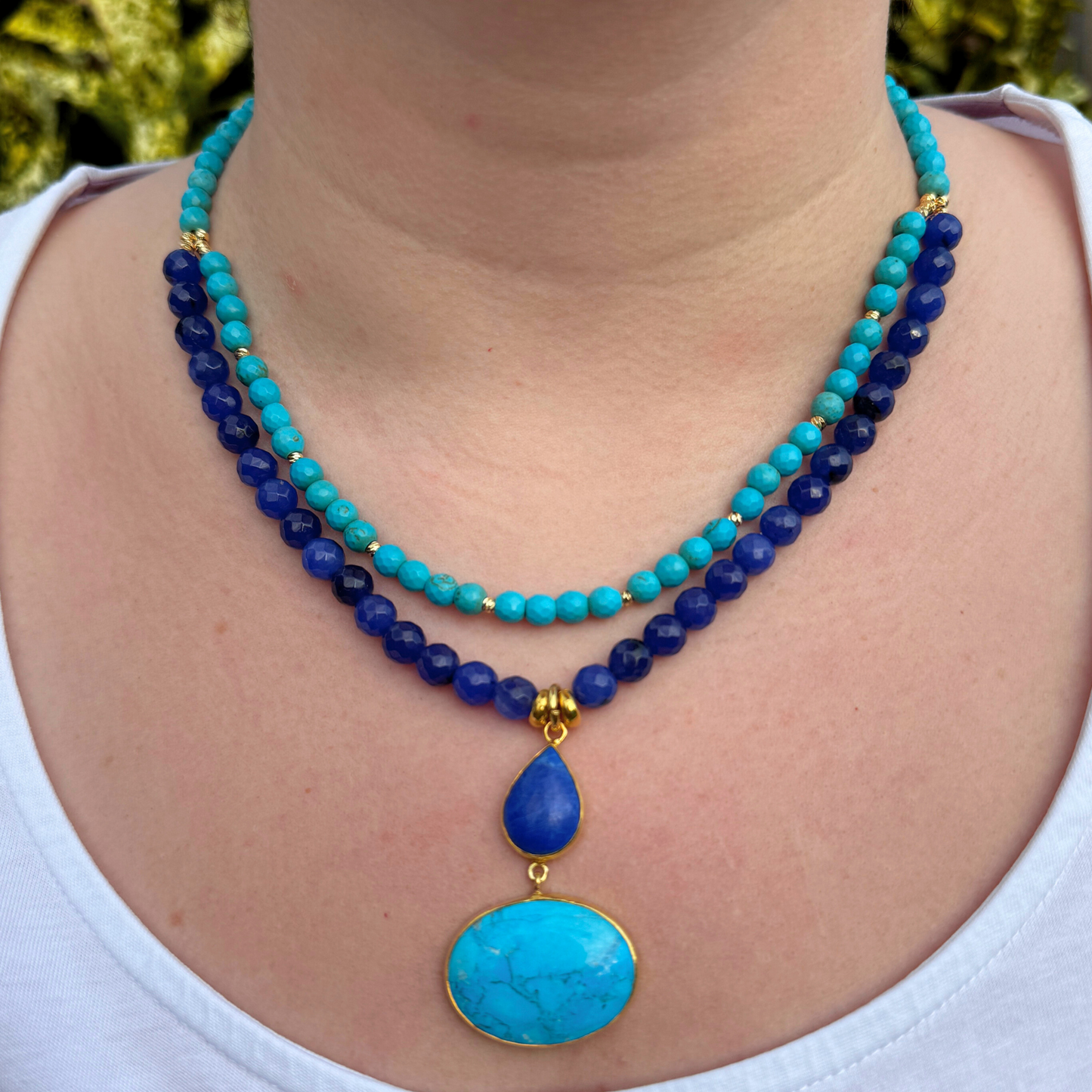 A stunning turquoise and lapis lazuli gemstone necklace featuring double strands and vibrant pendants, perfect for any occasion.